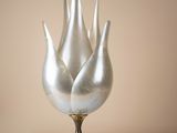 three silver vases sitting on a white table