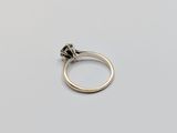 a close up of a diamond ring on a white surface