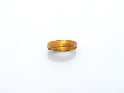 gros plan d'une bague en or sur une surface blanche