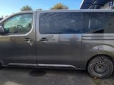a grey van parked in a parking lot next to a white van