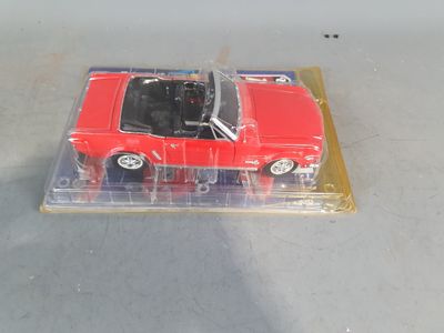 a red toy car in a clear plastic box