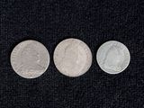 three different types of coins are shown on a black surface