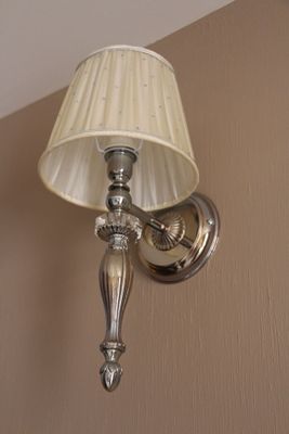 une lampe accrochée au mur à côté d'un abat-jour
