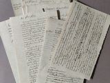 several old papers are stacked on top of each other on a table