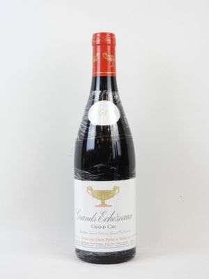 une bouteille de vin posée sur une table à côté d'un mur blanc