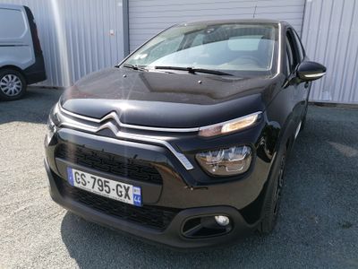 l'avant d'une Citroën noire garée devant un immeuble