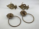 three brass napkin rings with lion heads on them
