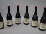 six bottles of wine are lined up in a row on a table