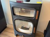 a small black stove sitting next to a black suitcase