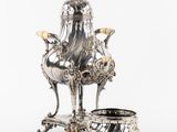 cafetière et bol en métal plaqué argent sur un socle, sur fond blanc