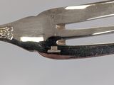 a silver fork with a flower on the end of it