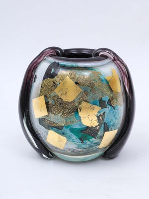 a glass vase with a gold and blue design on it