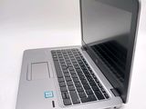 a silver laptop with a blue sticker on it