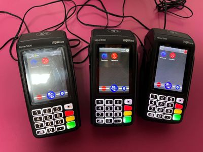 three cell phones sitting next to each other on a pink surface