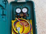 a green case with two gauges and a hose in it
