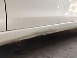 a close up of a white car with water droplets on it