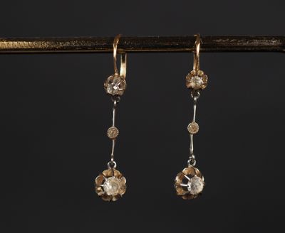 une paire de boucles d'oreilles en or et diamants suspendues à une branche