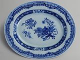 a blue and white plate with flowers and birds on it