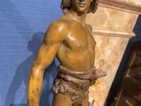 a statue of a man holding a knife and a sword
