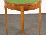a small round table with a green top and wooden legs