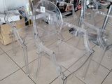 four clear chairs sitting on the floor in a store