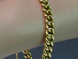 un gros plan sur le bras d'une personne portant un bracelet en or