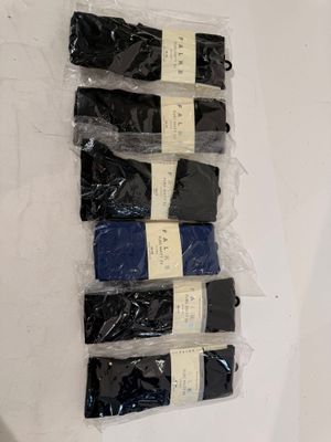 six pairs of black and blue socks sitting on top of a white surface
