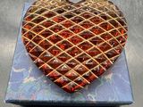 un gâteau en forme de cœur posé sur une assiette bleue, sur une table