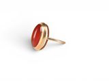 a close up of a red stone ring on a white background