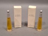 two small bottles of perfume sitting next to each other on a table