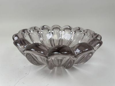 une image représentant un bol en verre posé sur une surface blanche