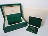 a green box with a watch and a card in it