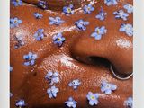 photograph of a close up of a person with blue flowers on their face
