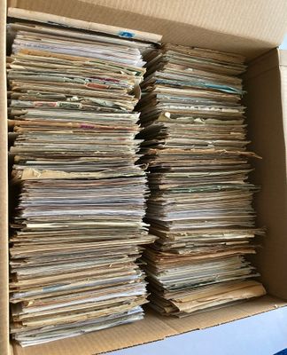 une boîte en carton ouverte, remplie d'une multitude de papiers, posée sur une table