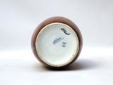 a brown and white vase with a bird on it