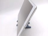 a tablet computer sitting on a stand on a white surface