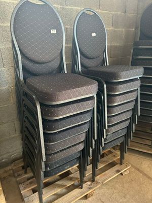 quatre chaises empilables posées sur une palette dans un entrepôt