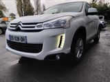 the front of a white citrole is parked in a parking lot