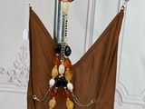 a brown dress hanging on a metal pole with beads