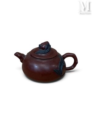 théière en céramique marron surmontée d'un oiseau