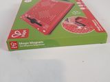 a red electronic device in a green box on a table