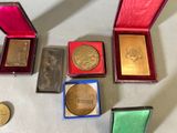 five different types of gold medals in a red case