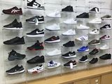 many pairs of shoes displayed on the wall in the store