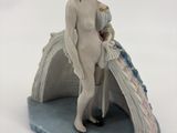 une figurine représentant une femme debout sur un rocher
