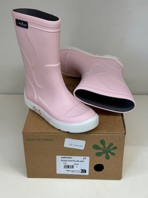 une paire de bottes de pluie roses posée sur une boîte en carton