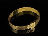 gold bracelet with a cross on it on a black surface