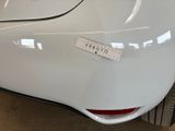 a close up of a white car with a sticker on it ' s bumper