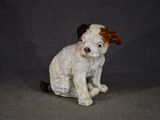 une petite figurine représentant un chien assis sur une table