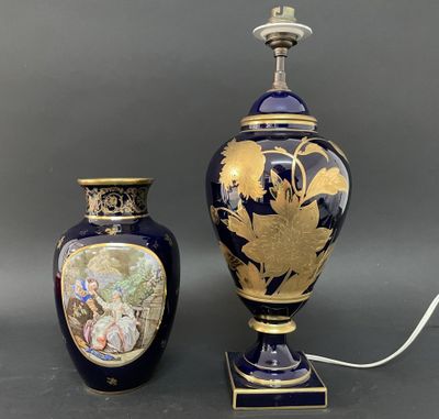 une paire de vases bleus et dorés posés sur une table à côté d'une lampe