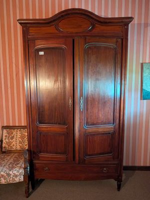 une armoire en bois devant laquelle se trouve une chaise